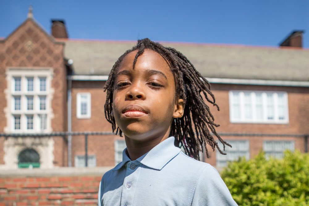 The Little Bit Foundation - young boy in front of school