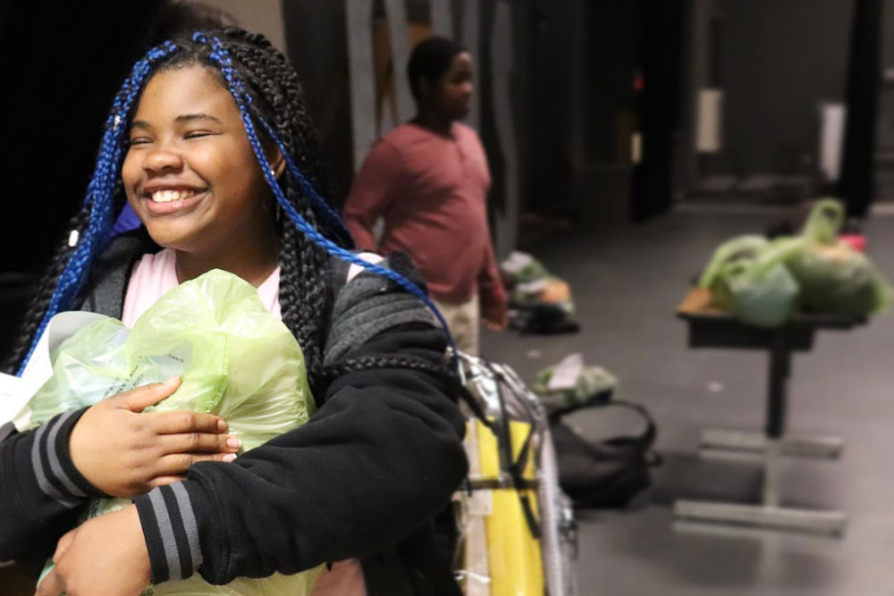 The Little Bit Foundation - happy girl with bag of clothes